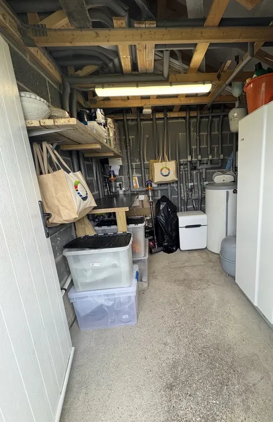 The same garage after: clear floor, labelled boxes stacked neatly and the walkway open